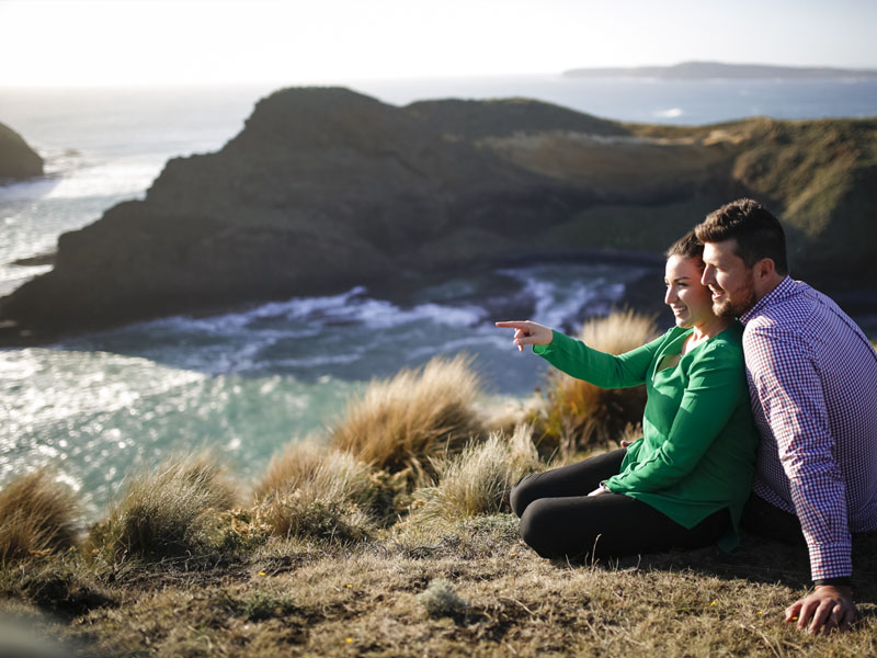 Couple sitting on the grass at kennaook/CapeGrim